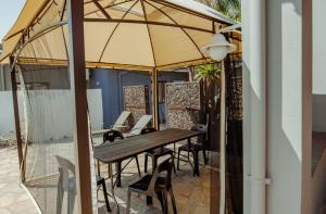a table and chairs under an umbrella on a patio at NJ SKY GUESTHOUSE & BOUTIQUE windhoek in Windhoek