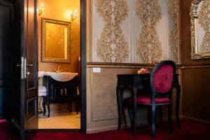 La salle de bains est pourvue d'une table, d'une chaise et d'un lavabo. dans l'établissement Belle Epoque Boutique (Adult Only), à Constanţa