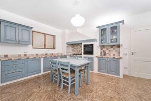 a kitchen with blue cabinets and a table at Villa Valentina in Tremezzo