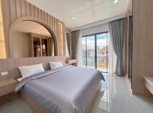 a bedroom with a large bed and a large window at 泰国芭提雅别墅 近中天海滩泳池别墅 in Jomtien Beach