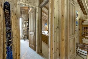 a log cabin hallway with a bedroom and a snowboard at Chalet Brunello in La Tzoumaz