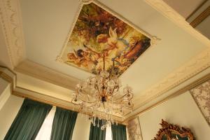 a chandelier hanging from a ceiling with a painting at Belle Epoque Boutique (Adult Only) in Constanţa