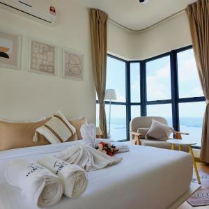 a bedroom with a large white bed with towels on it at Country Garden Danga Bay By Minshuku in Johor Bahru +178 photos