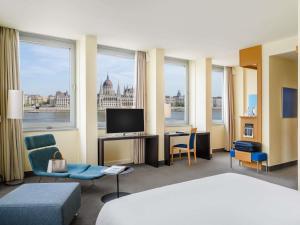 a hotel room with a bed and views of the city at Novotel Budapest Danube in Budapest
