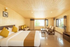 Una habitación de hotel con una cama grande y una mesa. en Hotel Sunny Cot - Free Mall Shuttle and Parking, en Mussoorie