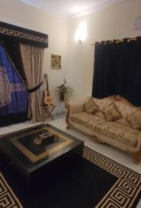a living room with a couch and a table at Luxurious 200 SQY Executive Furnished Villa for Rent in Karachi