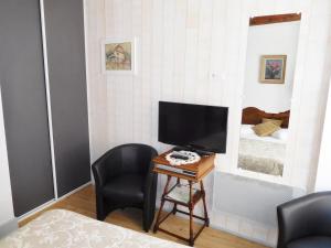 a room with two chairs and a television on a table at Location "Charme" in Riquewihr