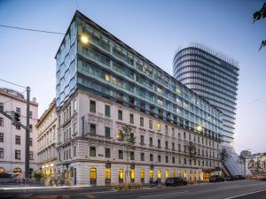 Un edificio alto en una calle de la ciudad con un edificio en Novotel Wien City, en Viena