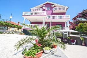 een roze huis met planten ervoor bij Apartments Villa Excellente Belvedere in Pula