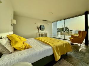 ein Schlafzimmer mit einem Bett mit einer gelben Decke darauf in der Unterkunft Casas do Moinho, Alentejo Country House in Santa Margarida da Serra