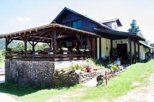 a building with a stone wall next to a house at B&B Villa Nena in Plitvica Selo