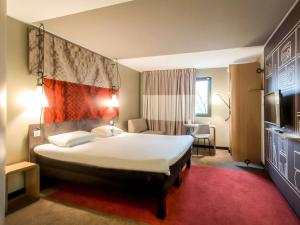 a hotel room with a large bed and a television at ibis Bordeaux Centre Bastide in Bordeaux +61 photos