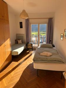 a bedroom with a bed and a large window at Fernblick in Sluderno