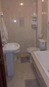 ボイロにあるApartamento Cabo de Cruzのバスルーム(洗面台、トイレ、バスタブ付)