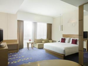 una camera d'albergo con un letto e un divano di Novotel Bandung a Bandung