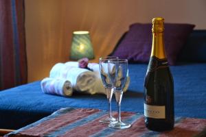 a bottle of champagne and a wine glass on a table at B&B Terra Niura in Nicolosi