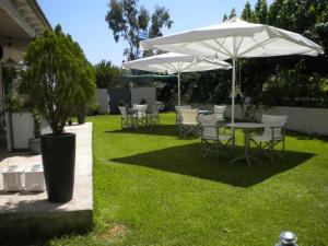 a patio with tables and chairs and an umbrella at Diavlos Studios in Agiokampos