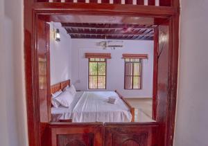 a bedroom with a bed in a room with a mirror at Cotelac Heritage Lake Resort by VOYE HOMES in Alleppey