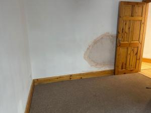 a room with a white wall and a wooden door at Brighton Heights With Sea Views in Brighton & Hove