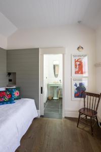 - une chambre avec un lit, une chaise et un lavabo dans l'établissement Chester Cottage - Design Haven in Castlemaine, à Castlemaine