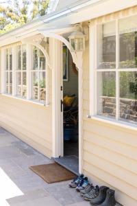 une porte d'entrée d'une maison avec des chaussures sur le porche dans l'établissement Chester Cottage - Design Haven in Castlemaine, à Castlemaine