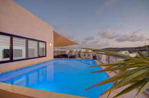 a swimming pool on the roof of a building at D Top View in St. Paul's Bay