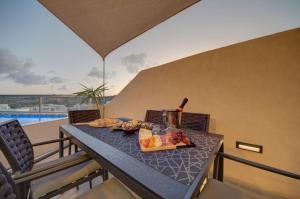 a table with a plate of food on a balcony at D Top View in St. Paul's Bay