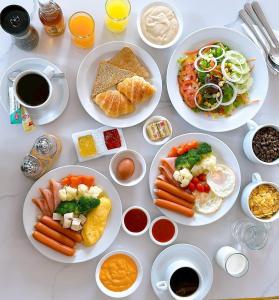 a white table with plates of food on it at Miloft Sathorn Hotel in Bangkok