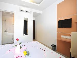 a bedroom with a flower vase on a bed at Guest House Nozz in Semarang