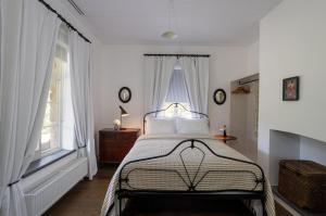 - une chambre avec un lit aux murs blancs et une fenêtre dans l'établissement Chester Cottage - Design Haven in Castlemaine, à Castlemaine
