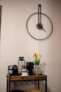 a clock on the wall above a table with flowers at Ina's Lake Garden Nicolas Suite in Lenno