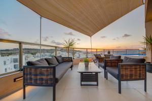 a balcony with couches and a table with a view at D Top View in St. Paul's Bay