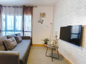 un soggiorno con divano e TV a schermo piatto di Sun&Sand Cotillo a Cotillo