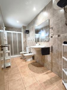 un bagno con lavandino, WC e specchio di Sun&Sand Cotillo a Cotillo