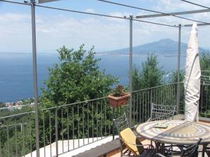 a balcony with a table and chairs and the ocean at Villetta Surriento in Sorrento