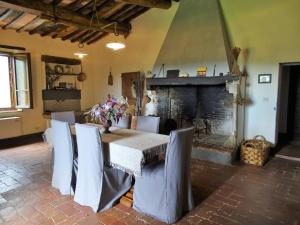 a dining room with a table and a fireplace at Podere Pievina Delle Corti - Dimora di Campagna in Sinalunga