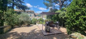 a grill on a wooden deck in a yard at Maison Barbaira 