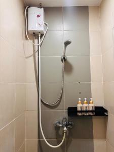 a shower with a shower head in a bathroom at 36 Bright Studio Getaway in Iloilo City +7 photos