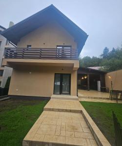 a house with a balcony on top of it at IUNIk in Azuga
