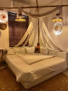 a bed in a bedroom with curtains and lights at CASA BOHEMIAn in Rishīkesh