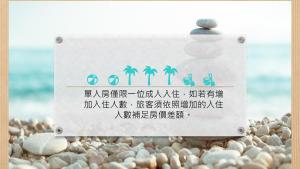 a sign on a rocky beach with writing on it at TK Happiness 168 B&B in Donggang