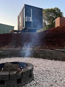 a fire pit with a building in the background at The Little Refuge by Tiny Away in Dunoon