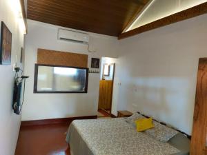 Schlafzimmer mit einem Bett und einem Fenster in der Unterkunft 36 Palms Heritage Villa in Kochi