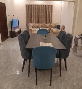 ein Esszimmer mit Tisch und Stühlen und einer Couch in der Unterkunft Guest House in Karatschi