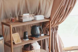 a shelf with items on it next to a curtain at Glamp Sora Furano in Nakafurano