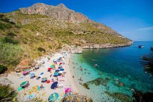 a beach with a bunch of people in the water at Casa Giummarra in San Vito lo Capo