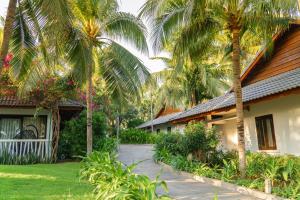 a house with palm trees in front of it at The Cliff Resort & Residences in Mui Ne