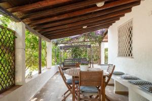 an outdoor dining room with a table and chairs at Villa Olivastro by Klodge in Olbia