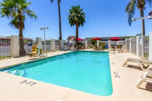 una gran piscina con sillas y palmeras en Motel 6 Tempe, AZ Phoenix Airport Priest Dr, en Tempe