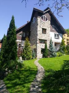 een groot stenen huis met een pad ervoor bij Pension Casa Contelui in Rîşnov